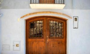 a wooden door with a window on a building at THE BLUE HOUSE OF COSTA BRAVA Leni's attic in Castelló d'Empúries