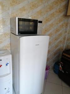 a microwave sitting on top of a refrigerator at The Ivy Suite- one bedroom 3 mins away from Ruiru Rainbow Resort in Ruiru