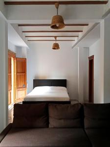 a bedroom with a bed and a couch in it at Apartamentos con encanto en pleno casco antiguo RON VALENCIAYOLE in Valencia