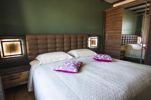 a bedroom with a large bed with two pink pillows at Garden Cottage in Palanga