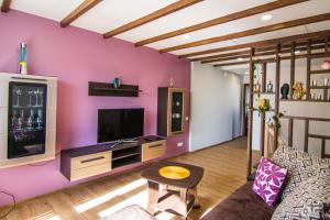 uma sala de estar com uma parede roxa em Garden Cottage em Palanga