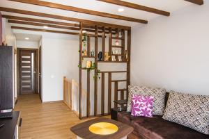 a living room with a couch and a spiral staircase at Garden Cottage in Palanga