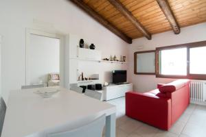 a living room with a red chair and a white table at CA' DEL CORDER - A secret corner of peace in Venice