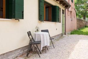 a table with two chairs sitting next to a building at CA' DEL CORDER - A secret corner of peace in Venice