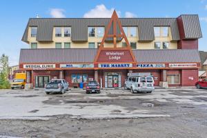 un edificio con coches estacionados en un estacionamiento en Cozy Corner - Whitefoot Lodge 126, en Big White