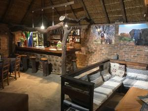 a bar with a couch in the middle of a room at Tamboti Bush Lodge in Hammanskraal