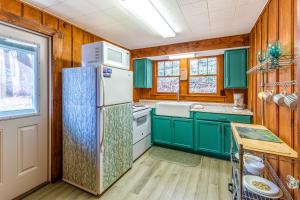 a kitchen with green cabinets and a refrigerator at Charlotte's Cabin in Waynesville