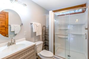 a bathroom with a shower and a toilet and a sink at Charlotte's Cabin in Waynesville +15 photos