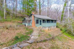 a small blue house in the middle of the woods at Charlotte's Cabin in Waynesville