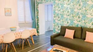 een woonkamer met een bank en een tafel bij Roubaix Gare wifi métro musée calme confort 6 lits - Gite le Ferrum in Roubaix