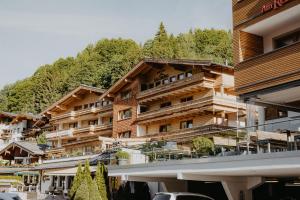 a large wooden building with a mountain in the background at Hotel Salzburg in Saalbach-Hinterglemm