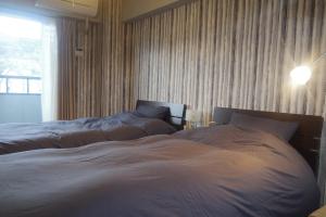 a bedroom with two beds and a window at Kyoto-Gion Tourist House in Kyoto