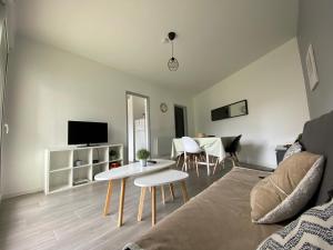 uma sala de estar com um sofá e uma mesa em Labenne Ocean - joli appt avec terrasse -T2 300m plage em Labenne