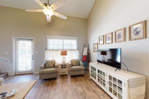 a living room with a flat screen tv and a couch at 21 Palms in Gulf Shores