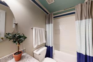 a bathroom with a toilet and a shower at 21 Palms in Gulf Shores +19 photos