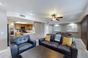 a living room with a couch and a ceiling fan at Luxe Lakewood Villa in Phoenix