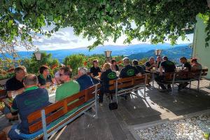 een groep mensen aan een tafel op banken bij Gasthof-Pension Ölberger in Wolfsberg