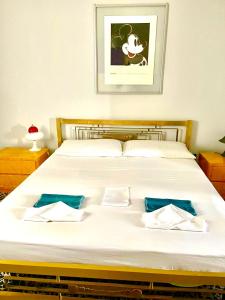 - une chambre avec un grand lit blanc et des oreillers bleus dans l'établissement Appartamenti Old era, à Tarente