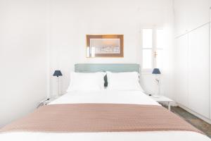 a white bedroom with a large bed with a blue headboard at Aeginia 2 in Perdika