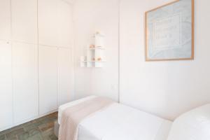 a white room with a bed and a picture on the wall at Aeginia 2 in Perdika