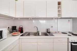 a kitchen with white cabinets and a stainless steel sink at Aeginia 2 in Perdika