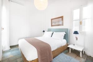 a bedroom with a large bed with white sheets and pillows at Aeginia 2 in Perdika