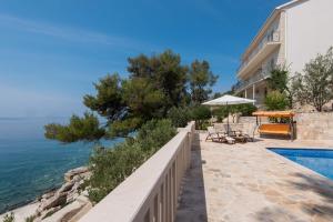 une maison avec une piscine à côté de l'océan dans l'établissement Apartment Prižba - Korčula, à Prižba