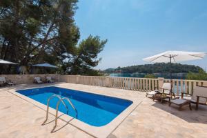piscina con sedie e ombrellone di Apartment Prižba - Korčula a Prižba