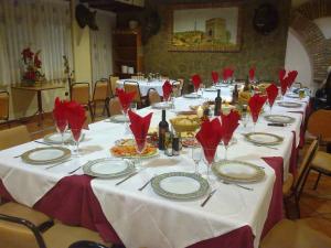 una mesa larga con servilletas rojas y copas de vino. en Arcojalon, en Arcos de Jalón