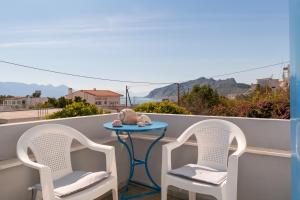 a table and two chairs on a balcony with a view at Aeginia 2 in Perdika