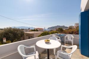 a white table and chairs on a balcony with a view at Aeginia 2 in Perdika