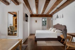 Un dormitorio con una cama, una mesa y un espejo. en Heritage Hotel Martinis Marchi, en Maslinica 133 fotos más