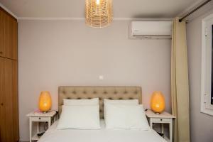 1 dormitorio con 1 cama con 2 lámparas en 2 mesas en Elena's apartment 3 en Argostoli