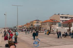 a group of people walking on a city street at RAFURADOURO in Ovar