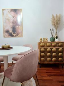 una sala da pranzo con tavolo, sedie e un dipinto di MiMì Luxury Home a Catania