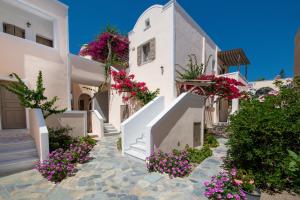 een rij witte huizen met bloemen voor hen bij Enjoy Villas in Kamari