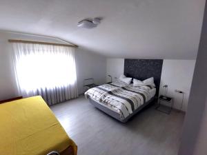 ein Schlafzimmer mit einem großen Bett und einem Fenster in der Unterkunft Ferienwohnung Sinsheim-Dühren in Sinsheim