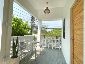 a porch with chairs and a table and a potted plant at D sleep Home Chiangmai in Chiang Mai