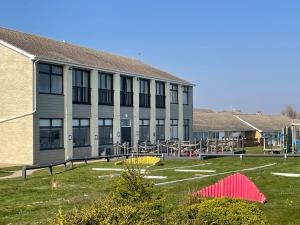 a building with a playground in front of it at The Beach House, Suffolk Coast in Lowestoft