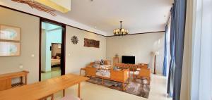 a living room with a table and a television at Sanya Haitangwan Shang Gong Yuan She Wellness Resort Villa in Sanya