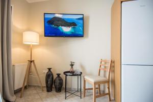 sala de estar con mesa y TV en la pared en Elena's apartment 3 en Argostoli