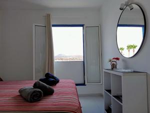 ein Schlafzimmer mit einem Bett und einem großen Spiegel in der Unterkunft Aguazul - A pie de piscina y vistas al mar in Puerto del Carmen + 42 Fotos