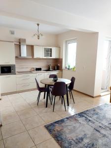 a kitchen and dining room with a table and chairs at Modlinska Apartments in Nowy Dwór Mazowiecki