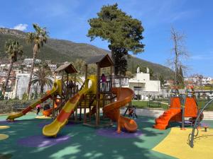 a park with a playground with slides and play equipment at Kamelija LUX in Đenovići