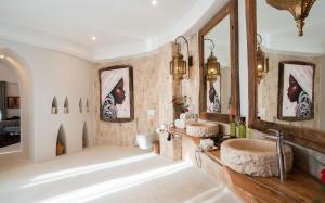a bathroom with two sinks and a large mirror at Xanadu Villas & Retreat in Bwejuu