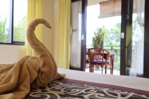 a towel sitting on a bed in a room at Wijaya Guest House Ubud in Ubud