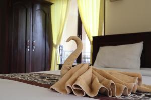 Una toalla sobre una cama en Wijaya Guest House Ubud, en Ubud