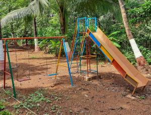 a playground with a slide in a park at A Latent Farm stay in Gimvi