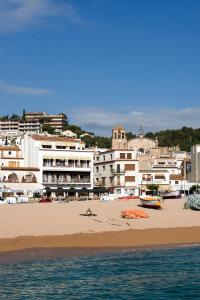 una playa con un grupo de edificios en el fondo en Hotel Capri, en Tossa de Mar