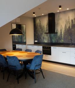 a kitchen with a wooden table and blue chairs at Turmalin Apartamenty in Świeradów-Zdrój